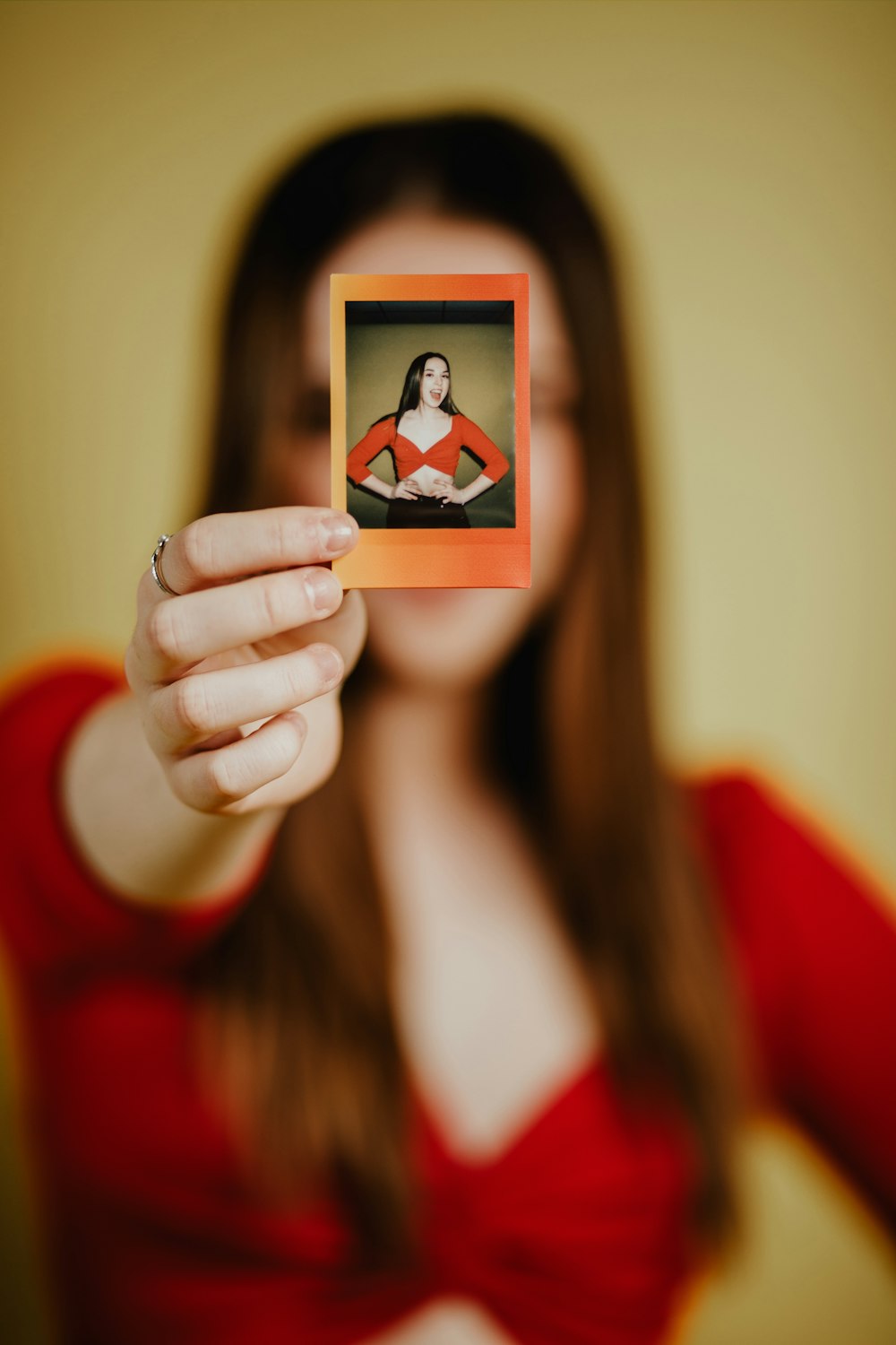 woman in red long sleeve shirt holding a picture of a man