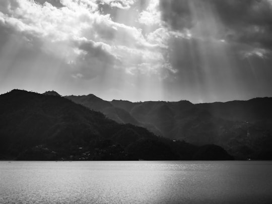 grayscale photo of mountains near body of water in Pokhara Nepal