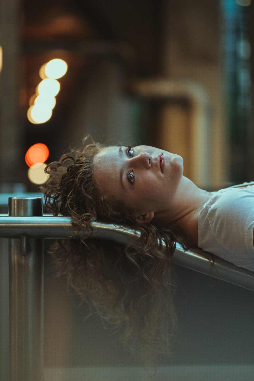 woman in white shirt leaning on gray metal railings