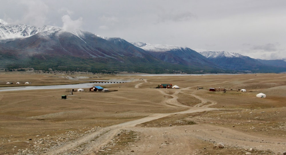 cars on brown field near mountain during daytime