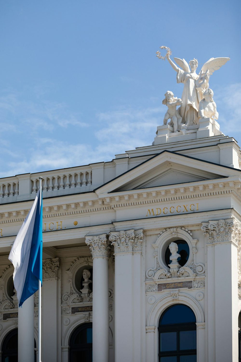 white concrete building with blue and white flag