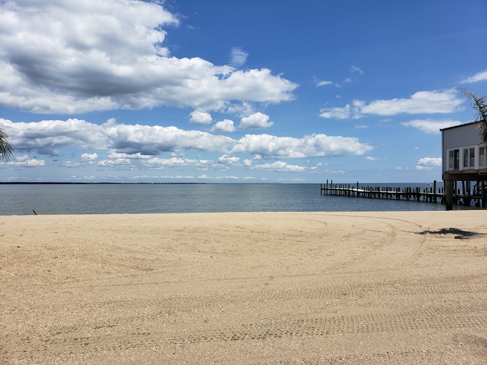 brown wooden dock on sea under blue and white cloudy sky during daytime