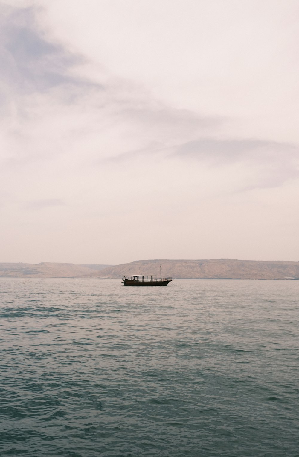 Schwarzes Boot auf See unter weißem Himmel tagsüber