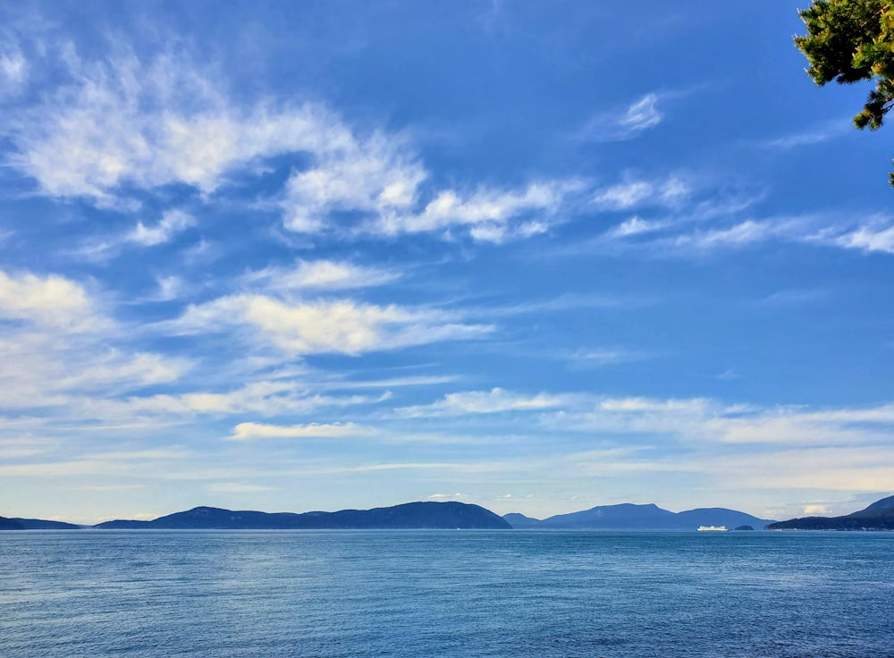 blue sea under blue sky and white clouds during daytime