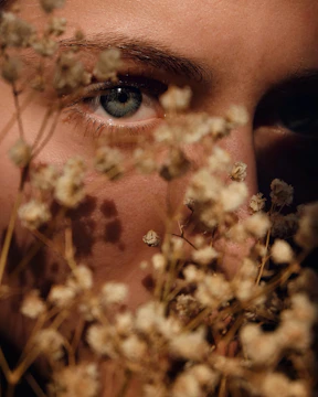 woman with brown eyes looking through leaves