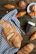 A rustic wooden table displaying an assortment of colorful cookies and bread.