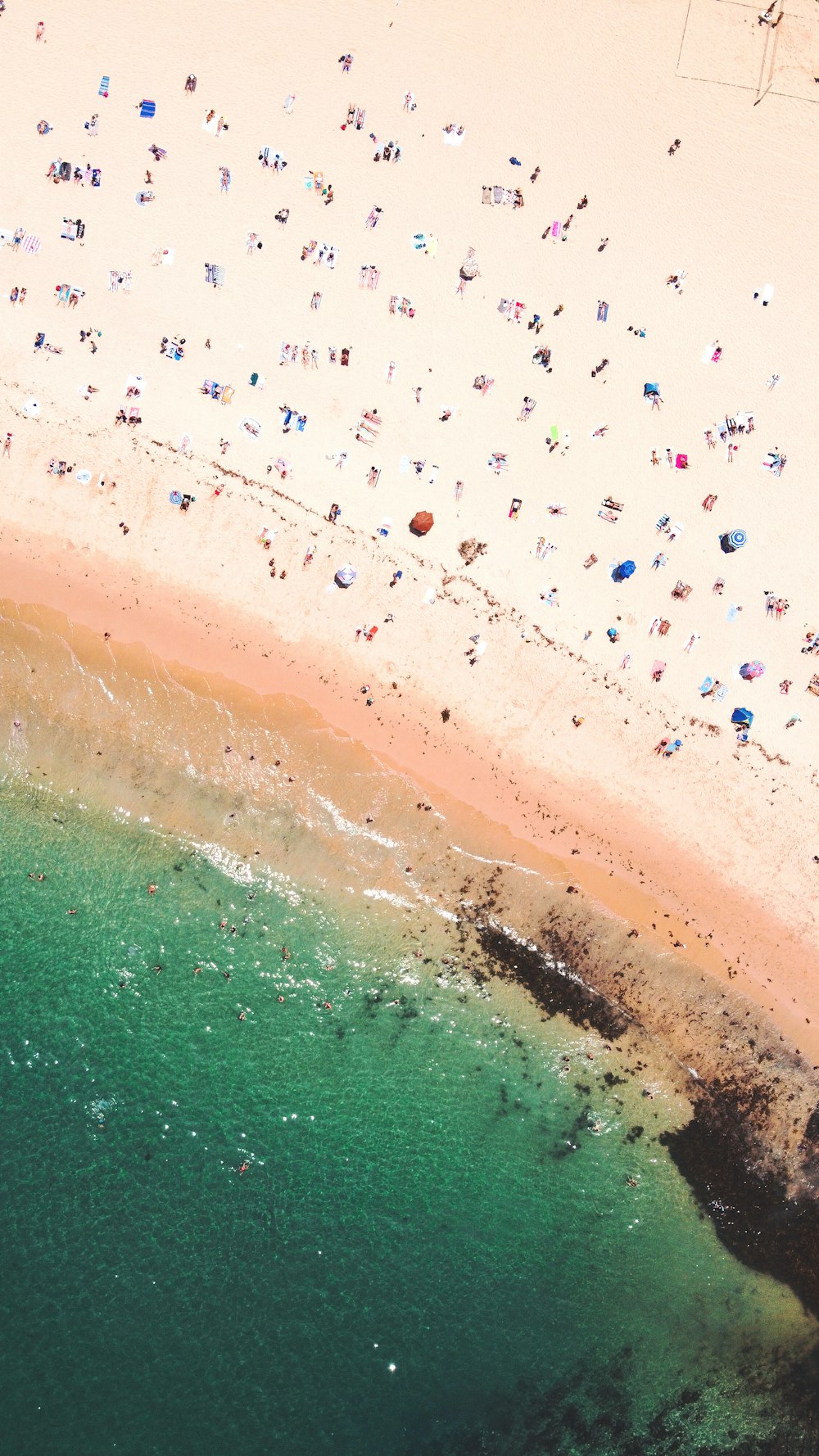 uma vista aérea de uma praia com muitas pessoas