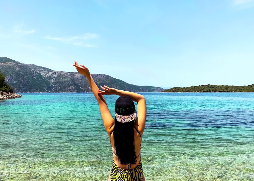 woman in black and brown dress standing on seashore during daytime