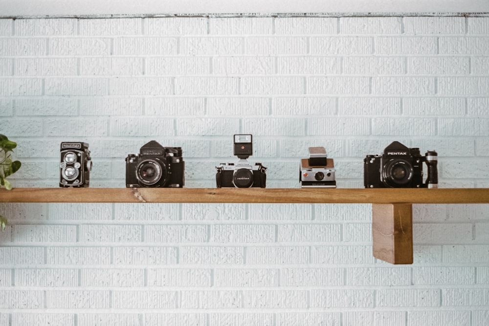 black and silver camera on brown wooden wall rack