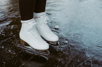 person wearing white leather boots ice skates google meet background