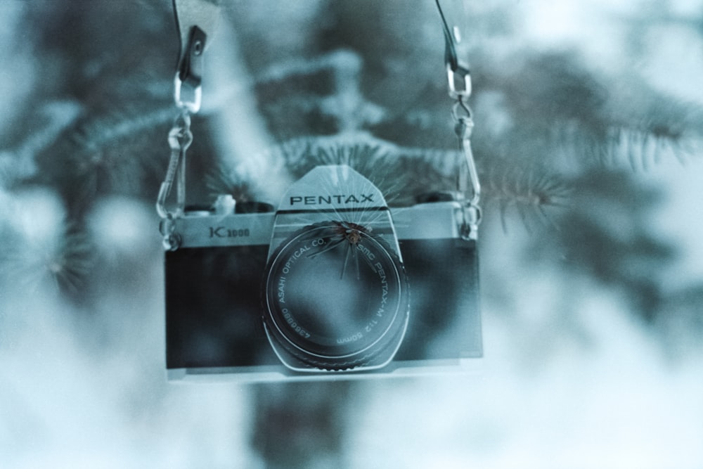 black and silver camera on white textile