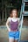 woman in blue and white stripe tank top and blue denim jeans standing beside gray metal