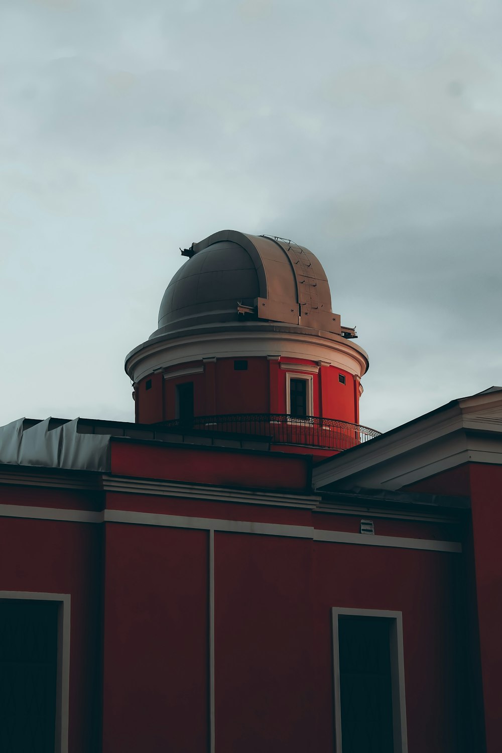 red and white concrete building under white clouds during daytime