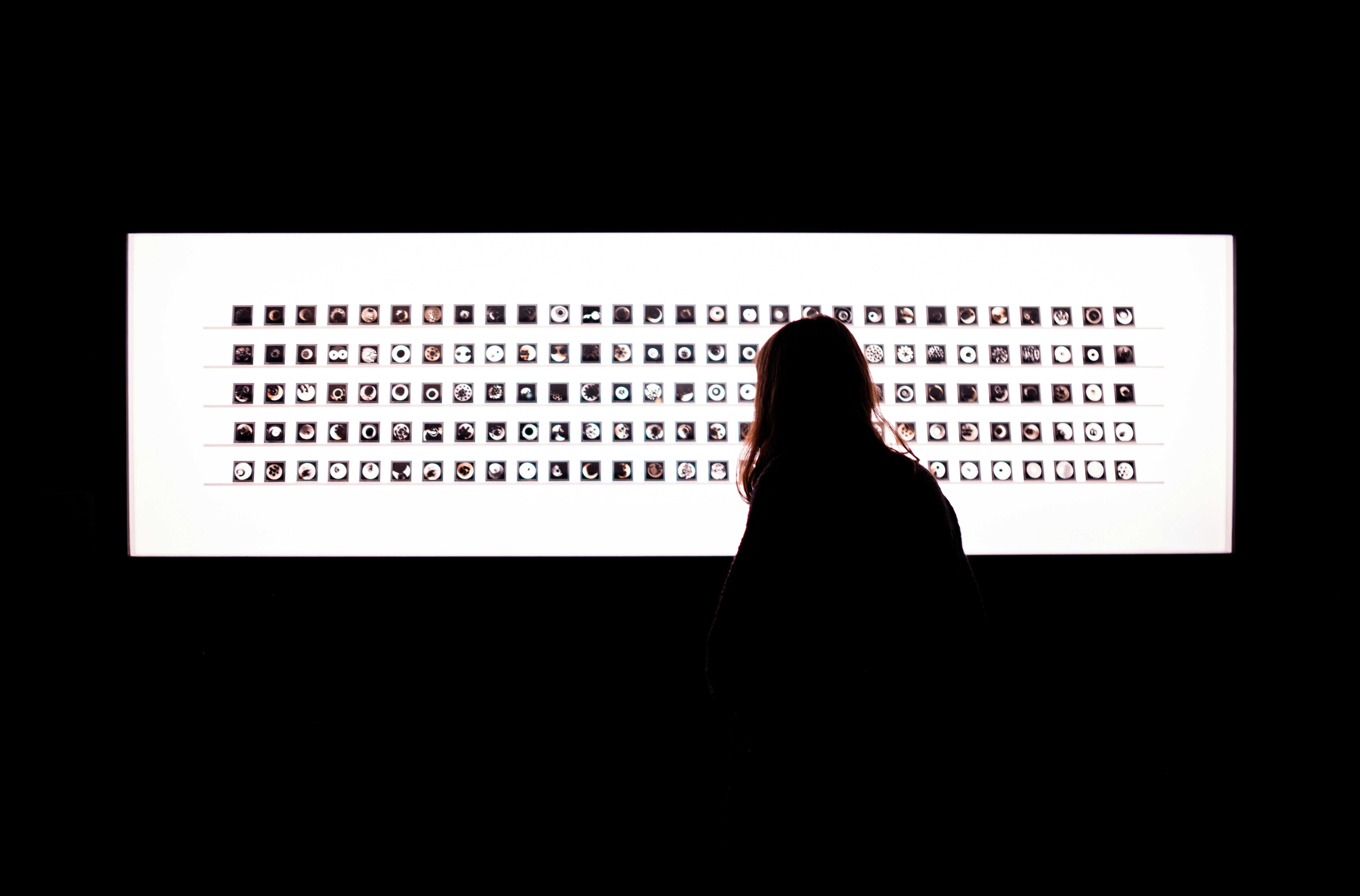 anonymous dark silhouette of a person typing on a laptop screen reflecting digital data