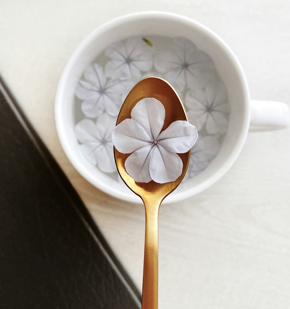 white and red floral ceramic mug with brown wooden spoon