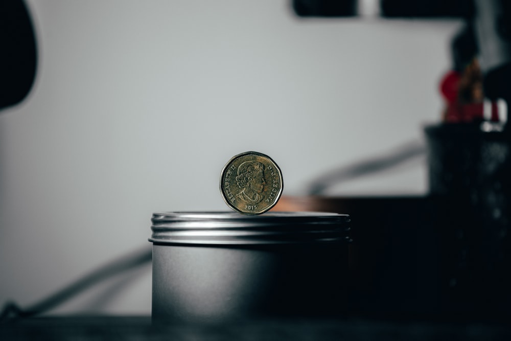 silver round coin on black surface