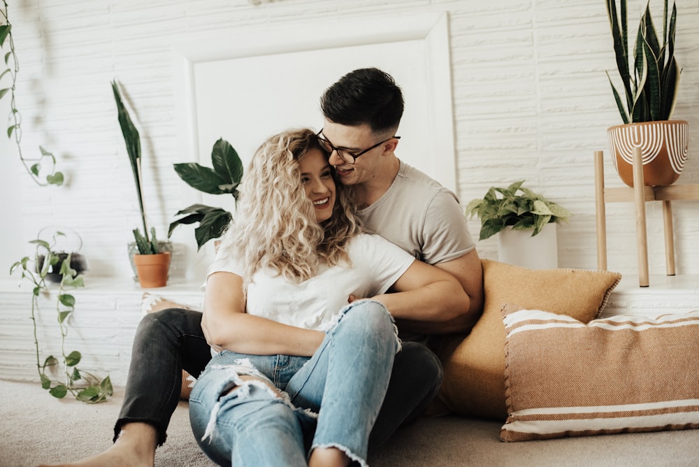 man and woman sitting on brown couch