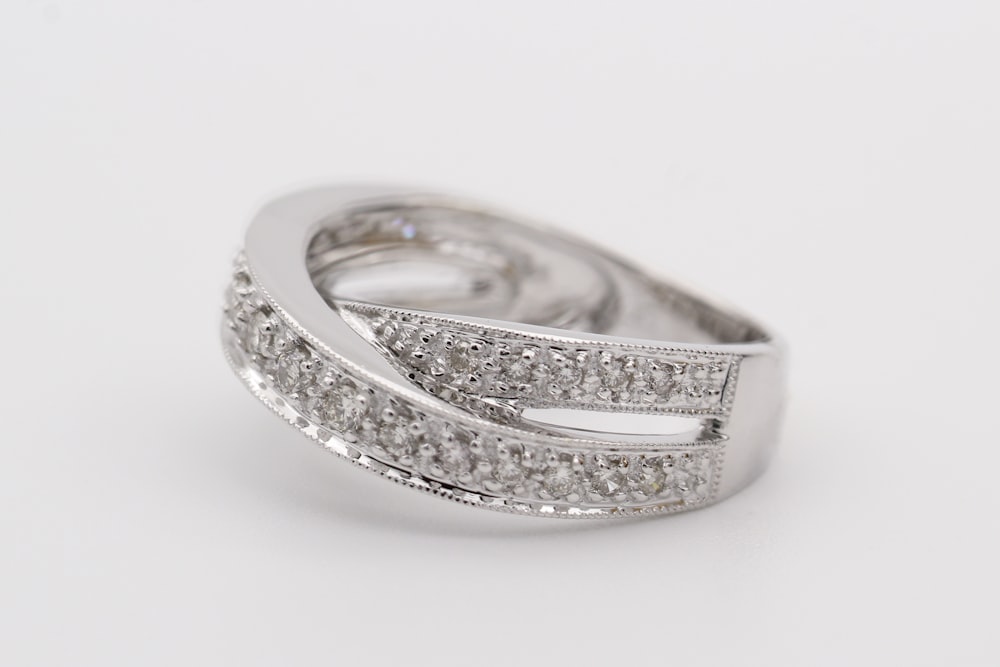 anel de diamante de prata na superfície branca