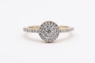 silver diamond studded ring on white surface