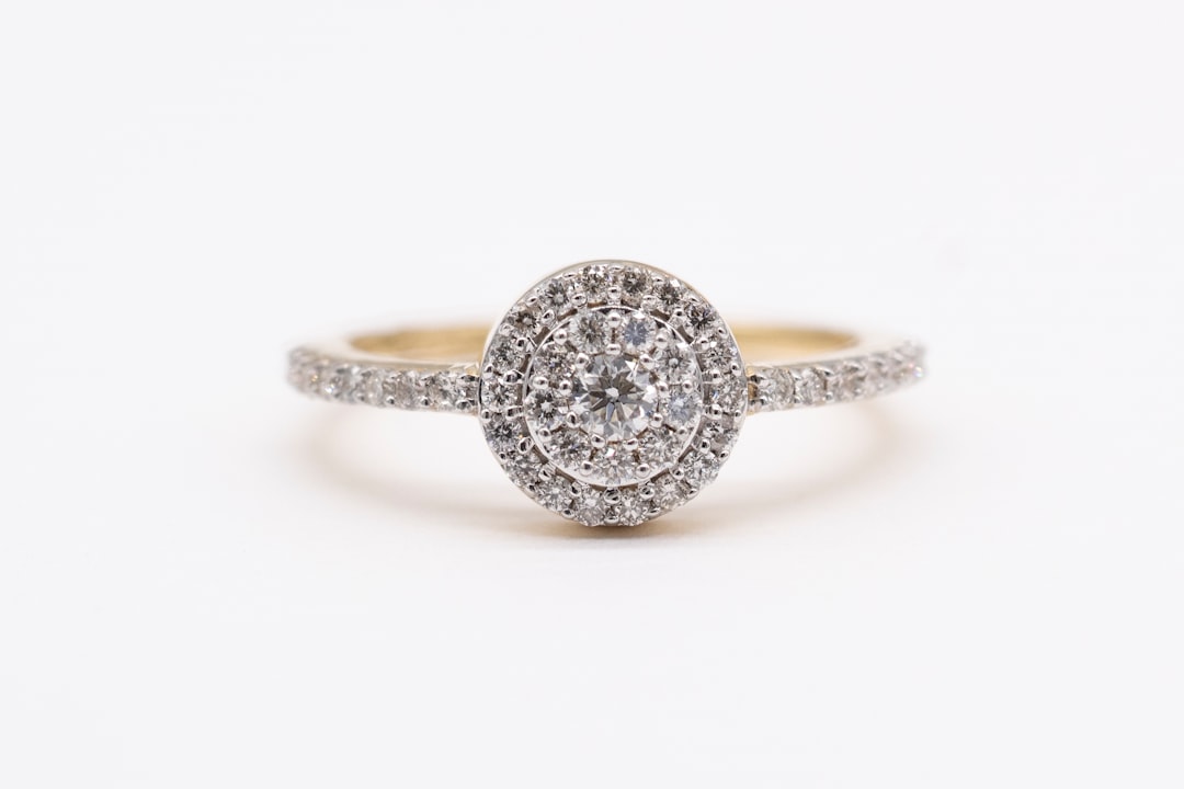 silver diamond studded ring on white surface