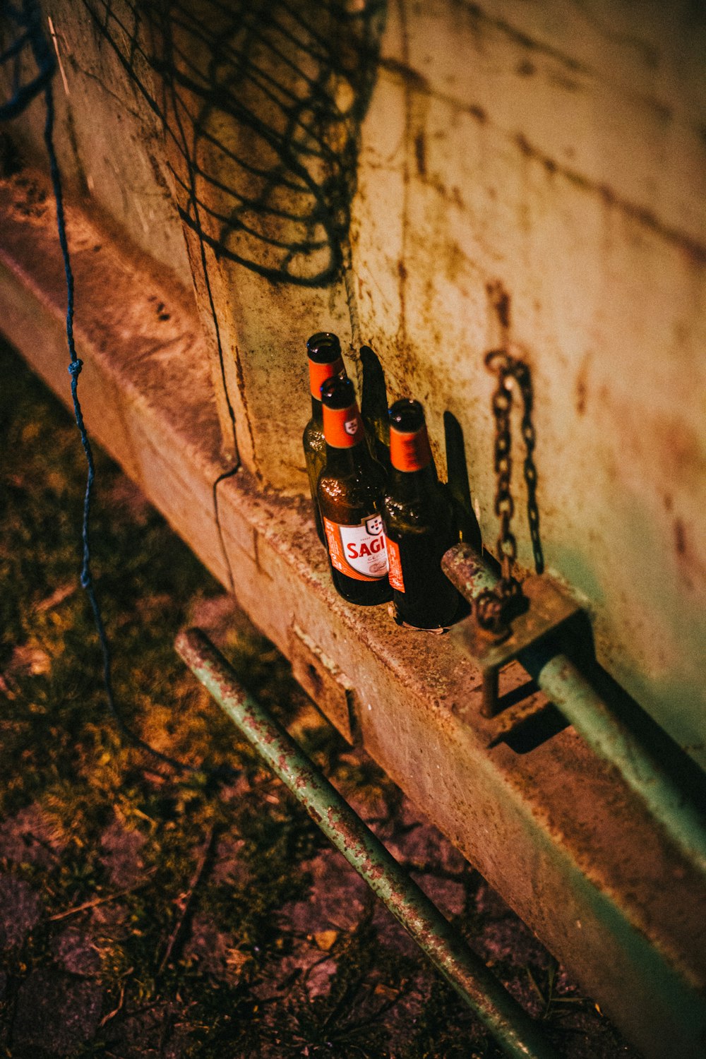 3 brown glass bottles on brown concrete wall