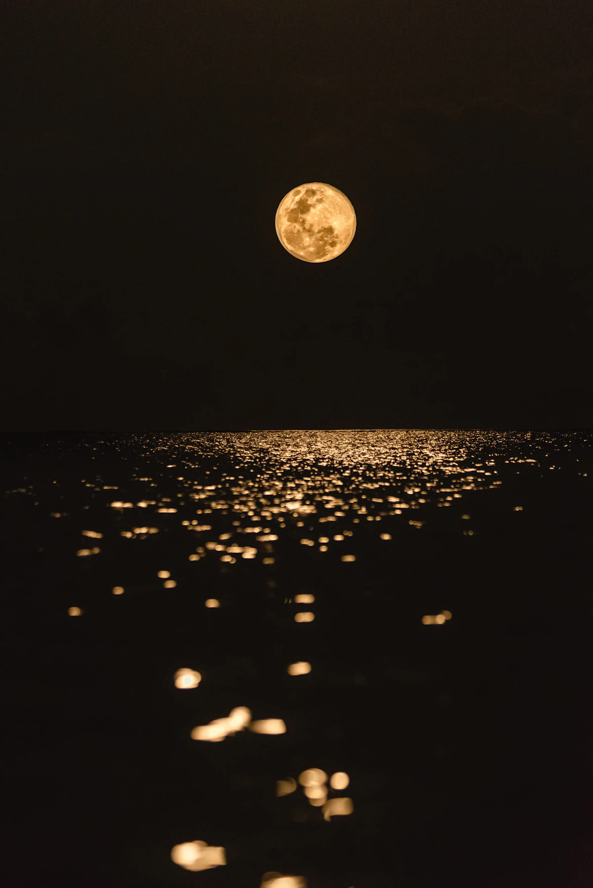 A glowing full moon over a still body of water at night, the traditional and most universally aligned charging source for amethyst