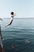 Swimmers diving into the calm Adriatic Sea from the ship's sun deck at sunrise.