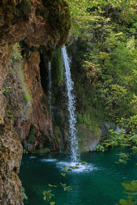 water falls in the middle of brown rocky mountain in Plitvička Jezera Croatia