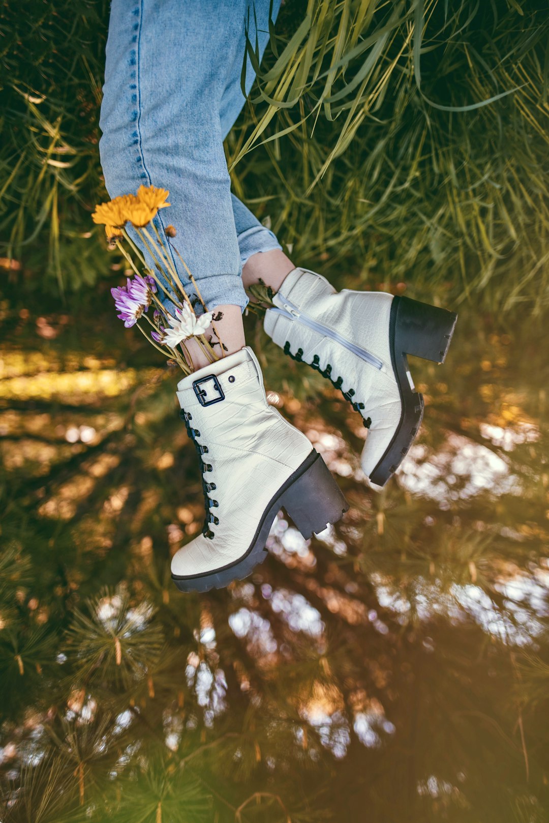 person in blue denim jeans and white and black high top sneakers