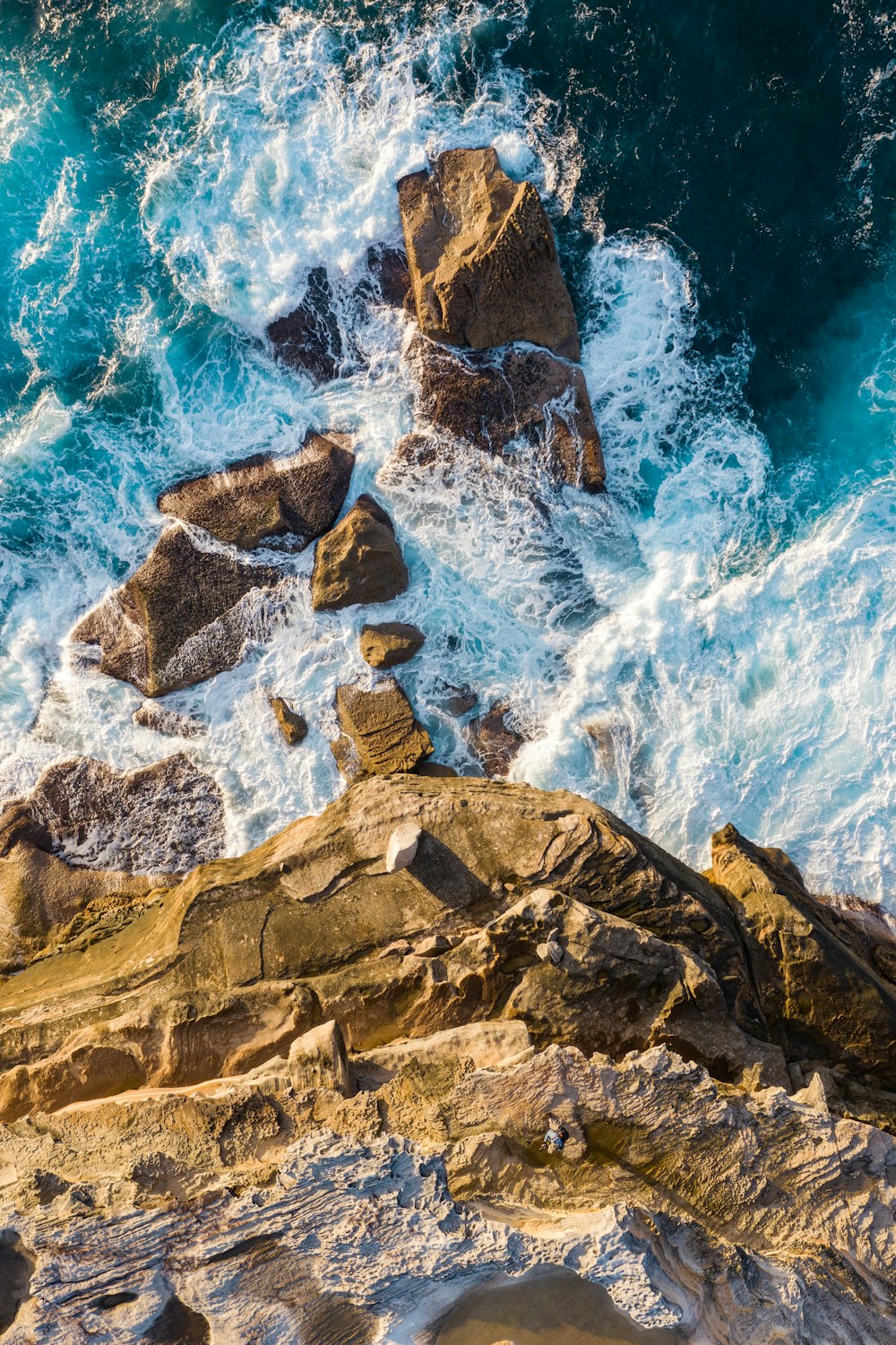 Montagna rocciosa marrone accanto all'acqua blu del mare durante il giorno