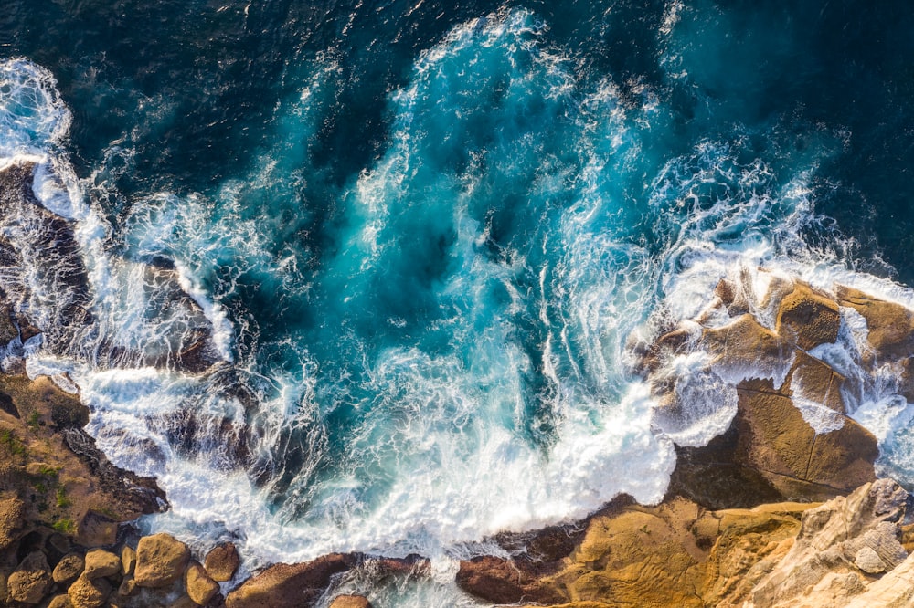 water waves hitting brown rocks