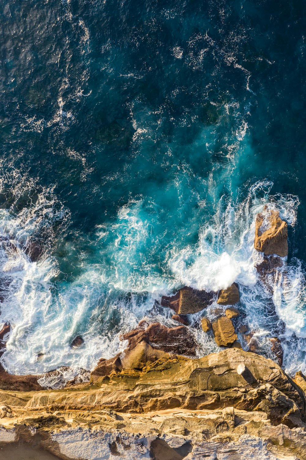 brown rocky shore with water waves during daytime