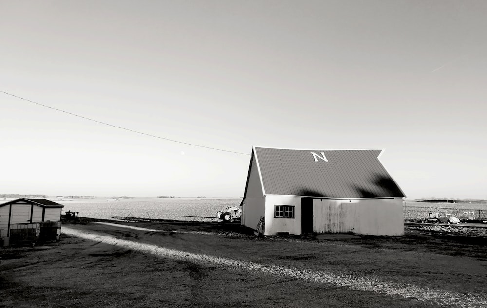 Graustufenfoto von Holzhaus am Strand