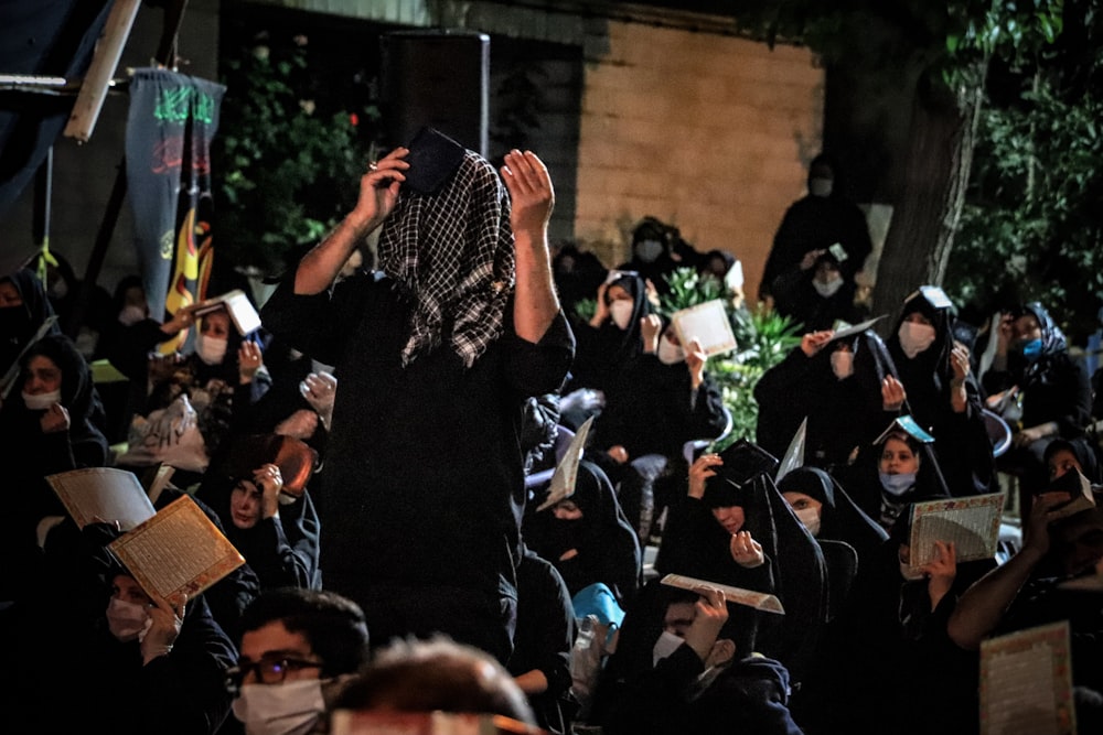 people in black shirt raising their hands