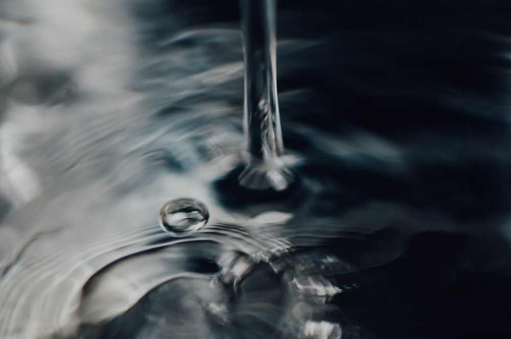 water drop in grayscale photography