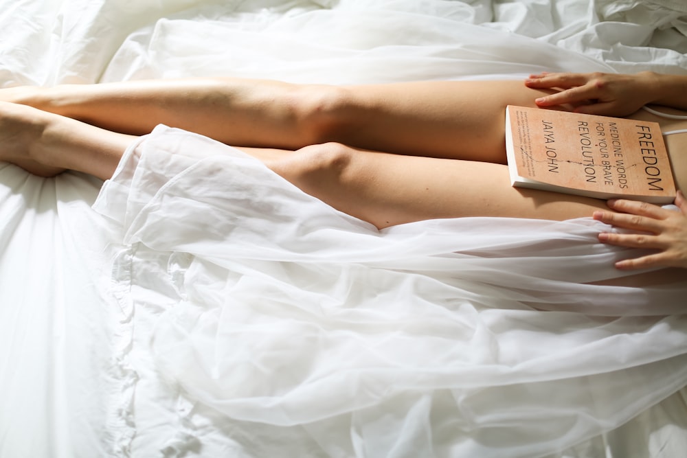 woman lying on bed reading book
