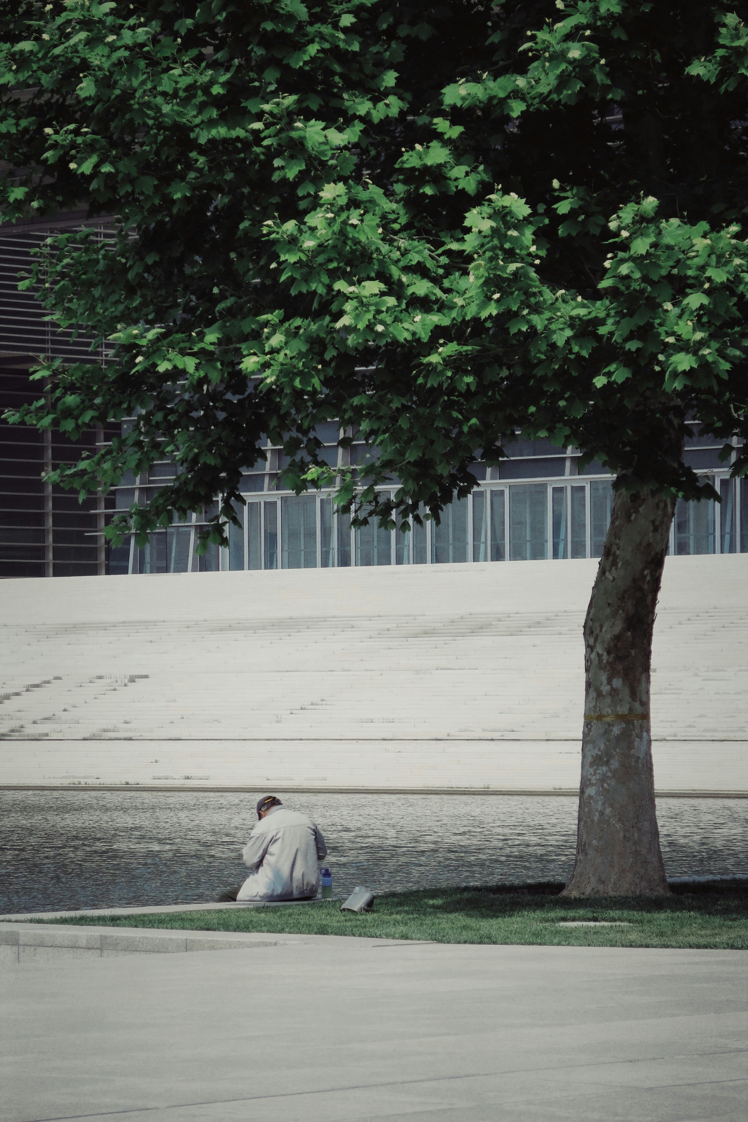 man in white thobe sitting on gray concrete floor during daytime