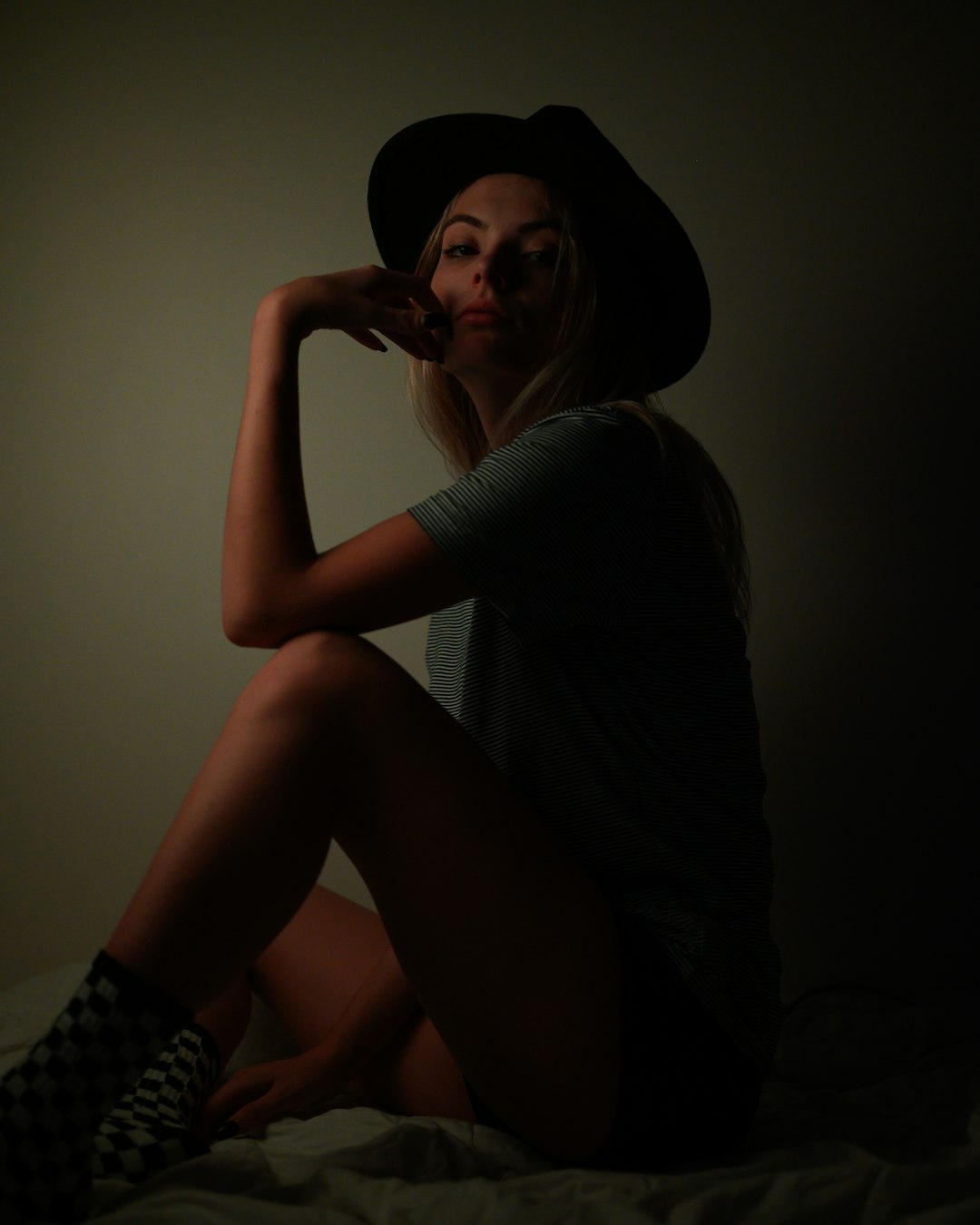 woman in gray long sleeve shirt and black and white checkered skirt sitting on brown wooden