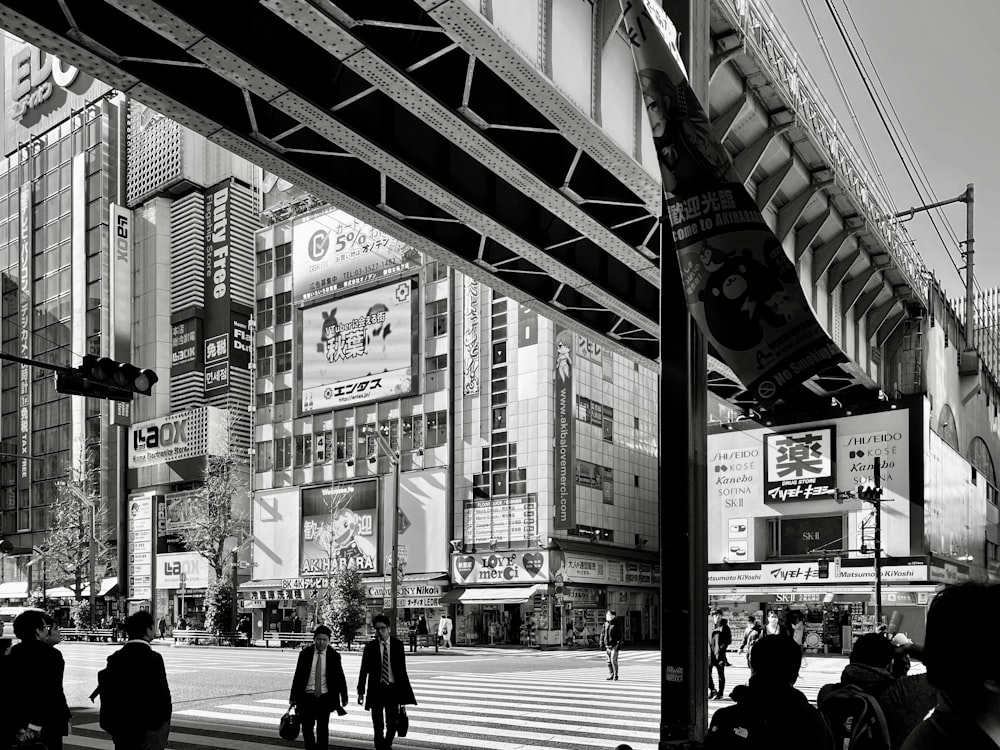 grayscale photo of people walking on sidewalk