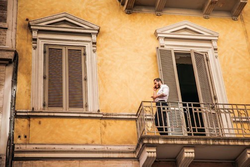 Friendly property manager talking on phone by a home exterior.
