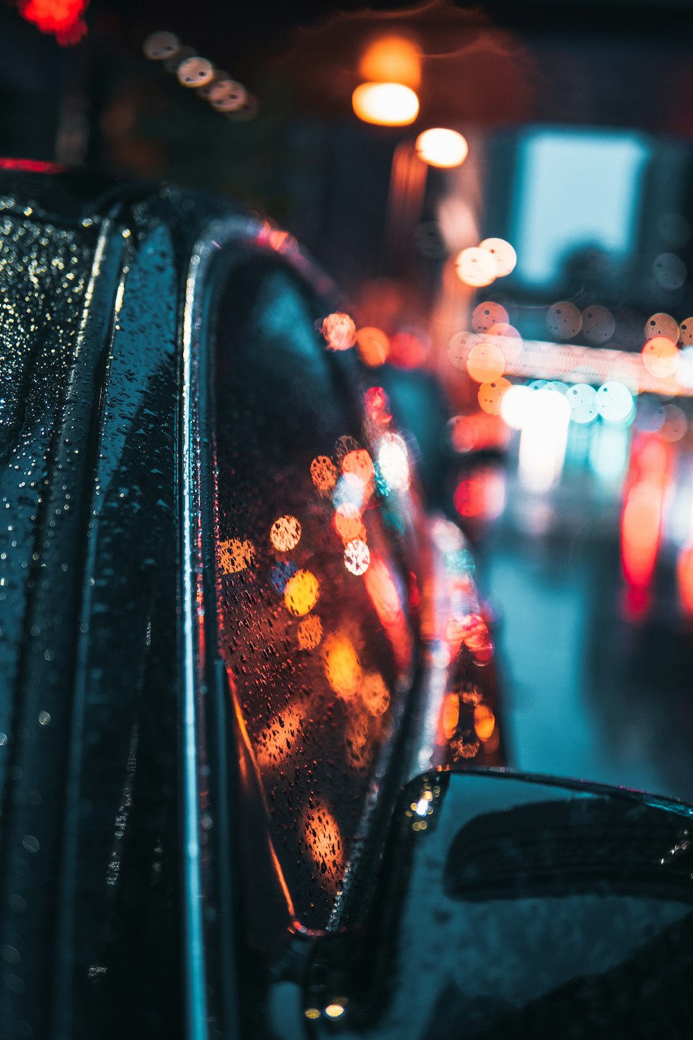 black car side mirror with water droplets