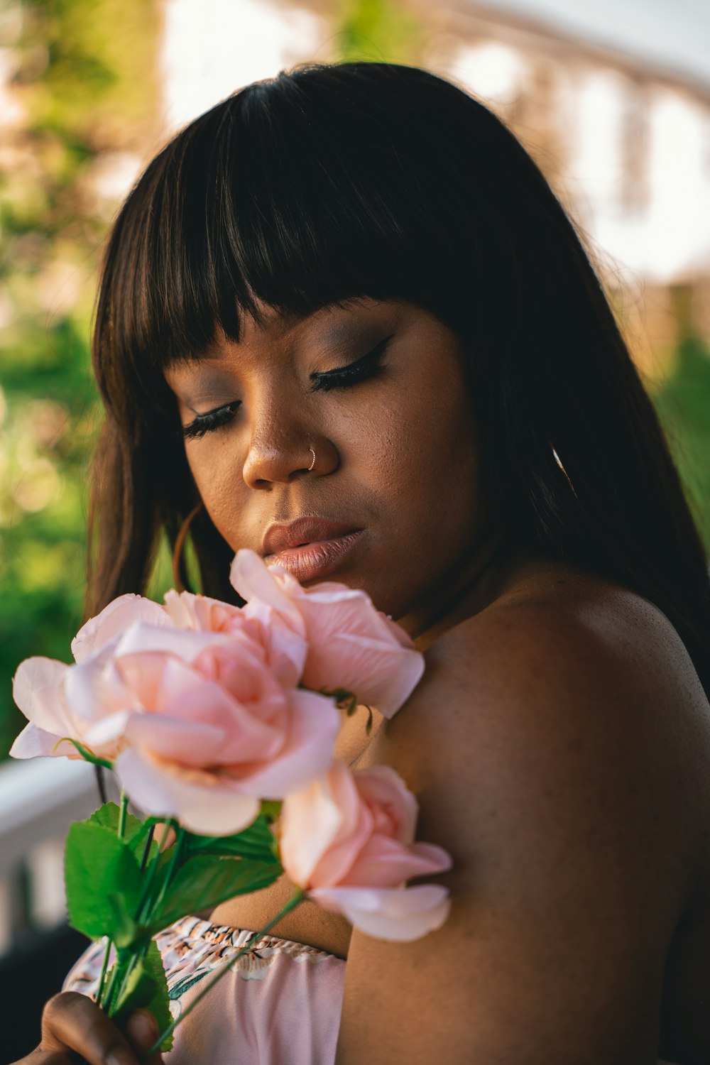 woman holding pink rose during daytime