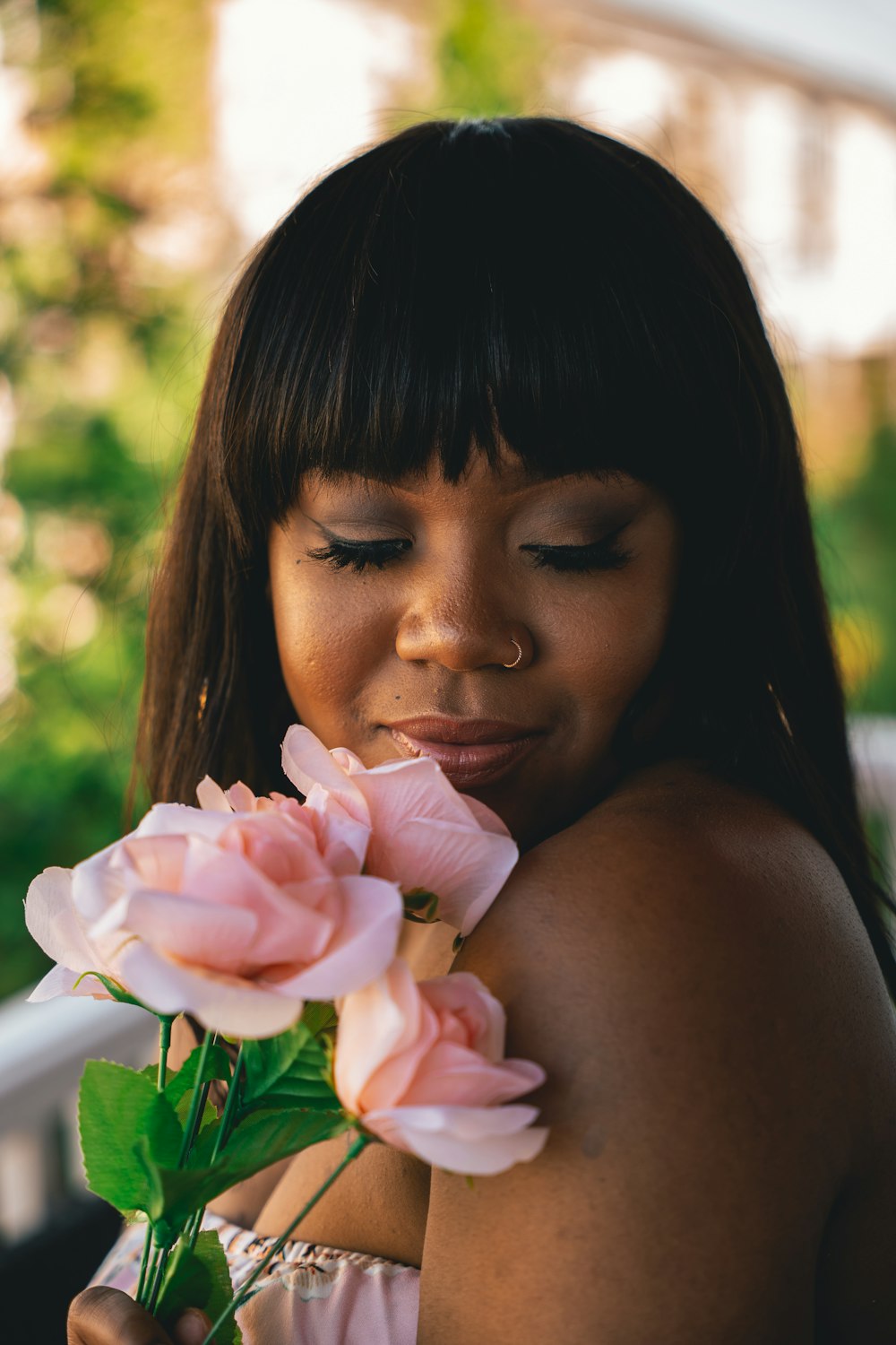girl holding pink flower during daytime
