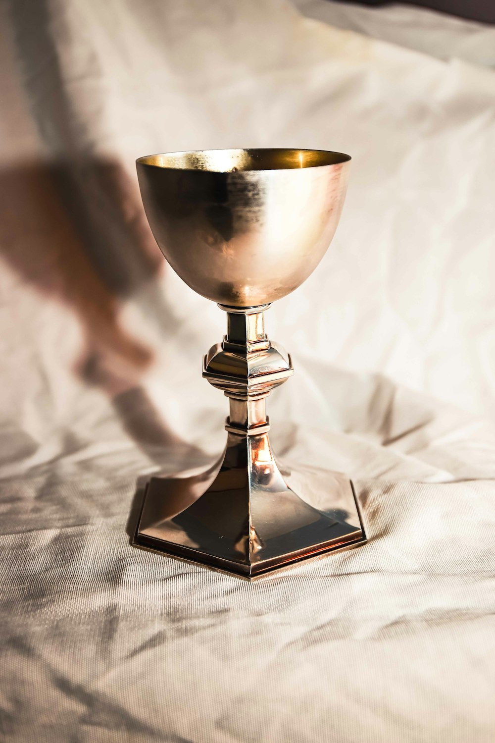 gold and silver footed glass on white textile