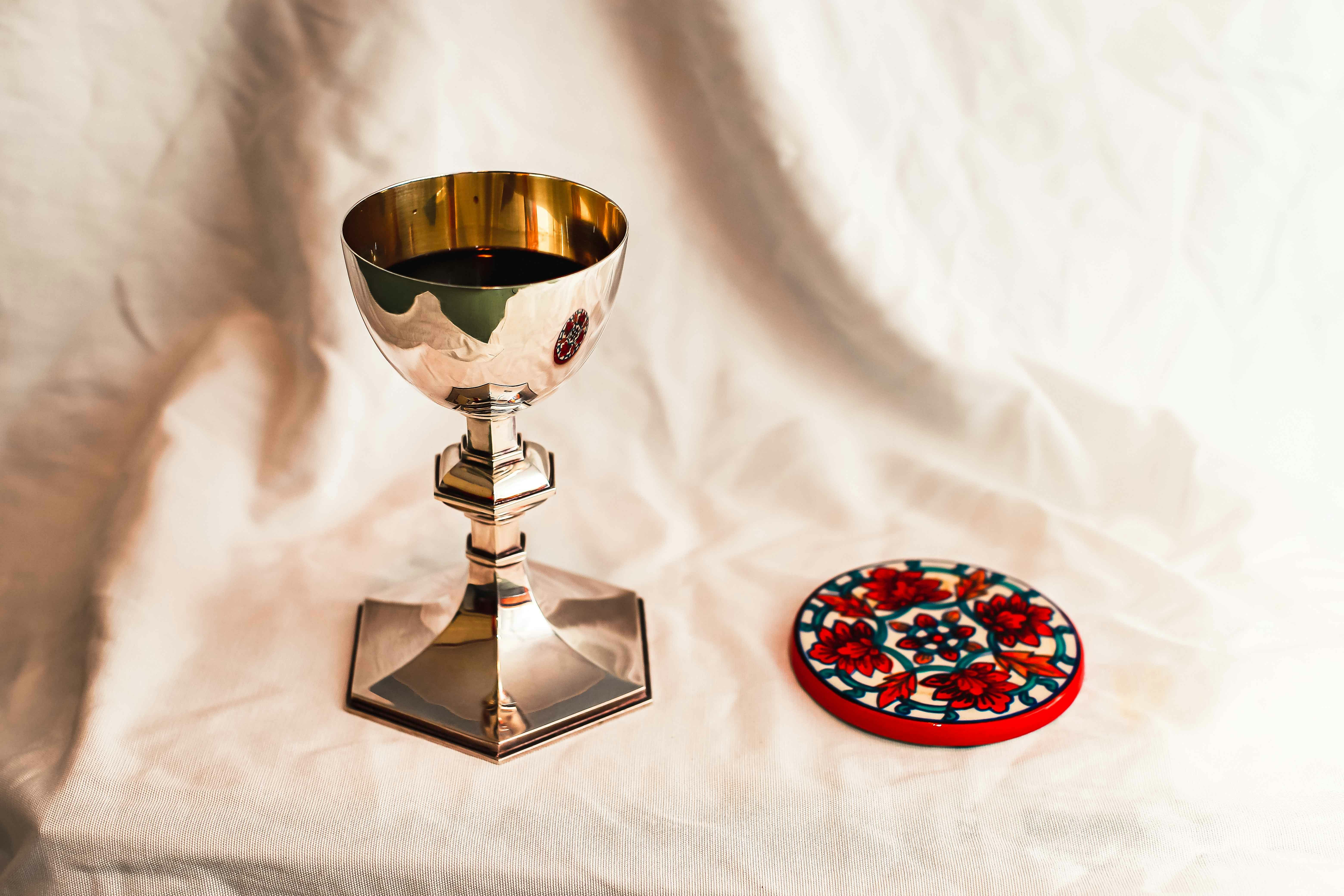 silver and red wine glass on white table cloth