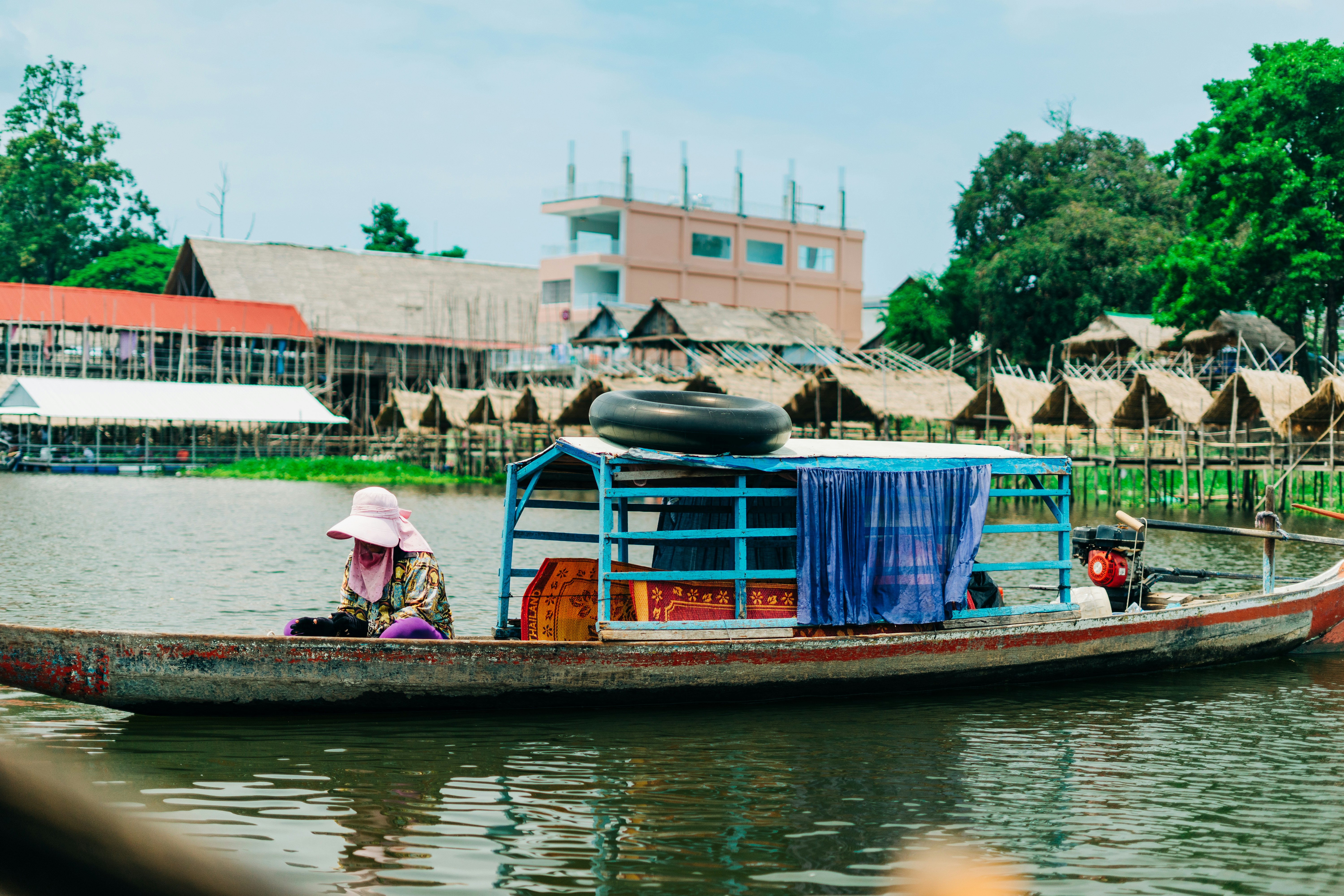 woman in pink hat sitting on brown boat during daytime