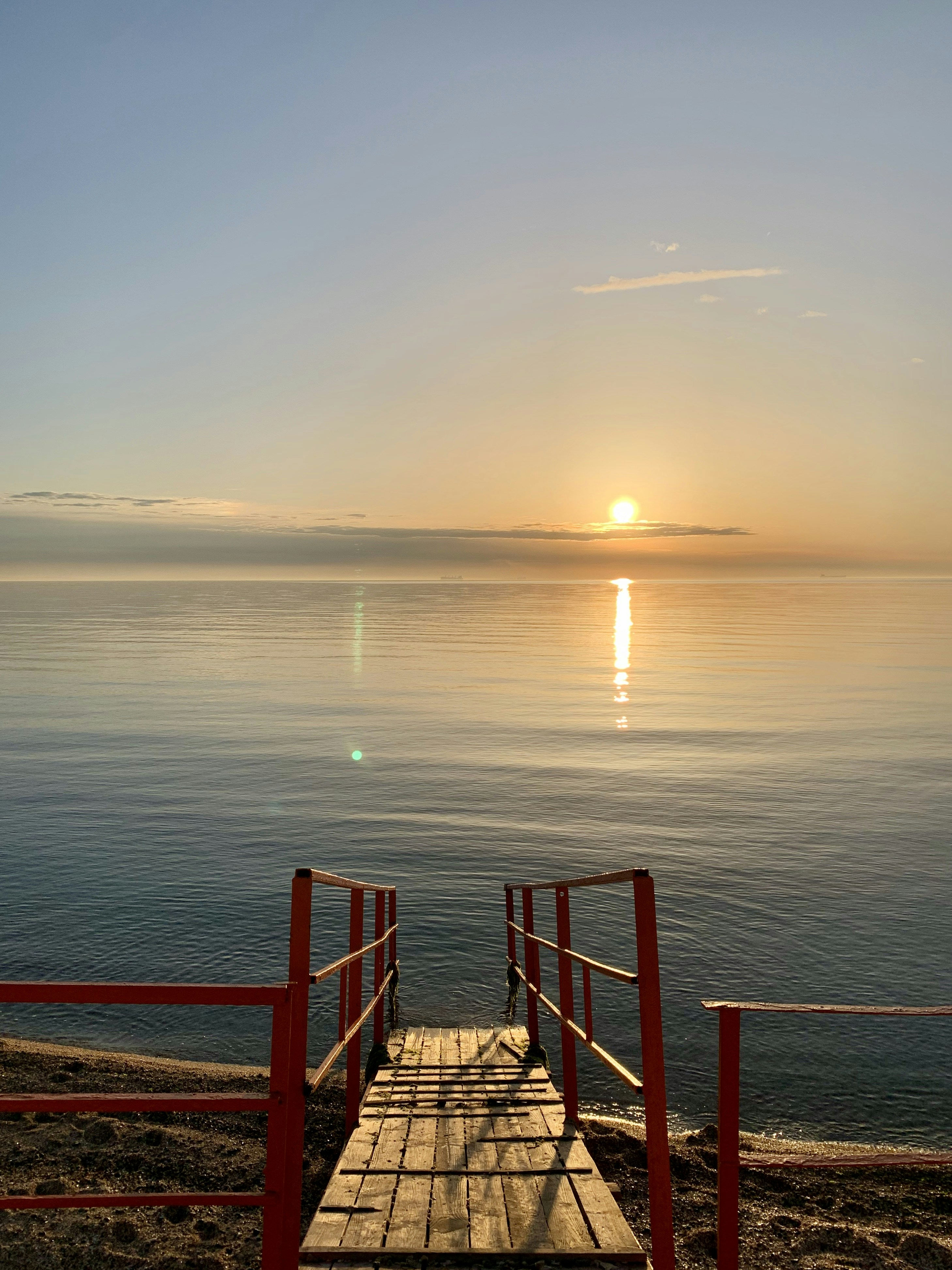 brown wooden fence on sea during sunset