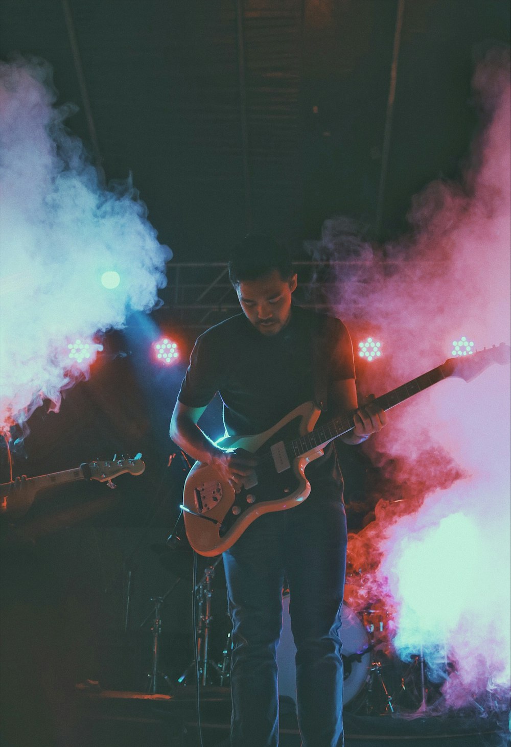 man in black crew neck t-shirt playing brown electric guitar