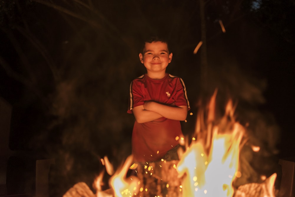 boy in red polo shirt holding lighted sparkler