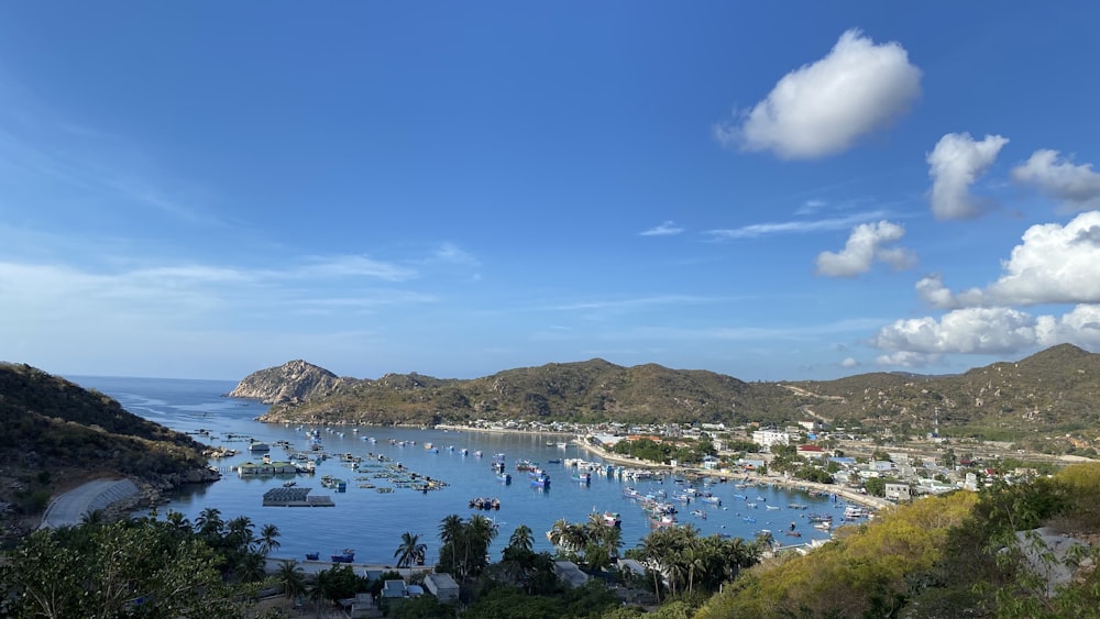 white boats on sea near mountain under blue sky during daytime